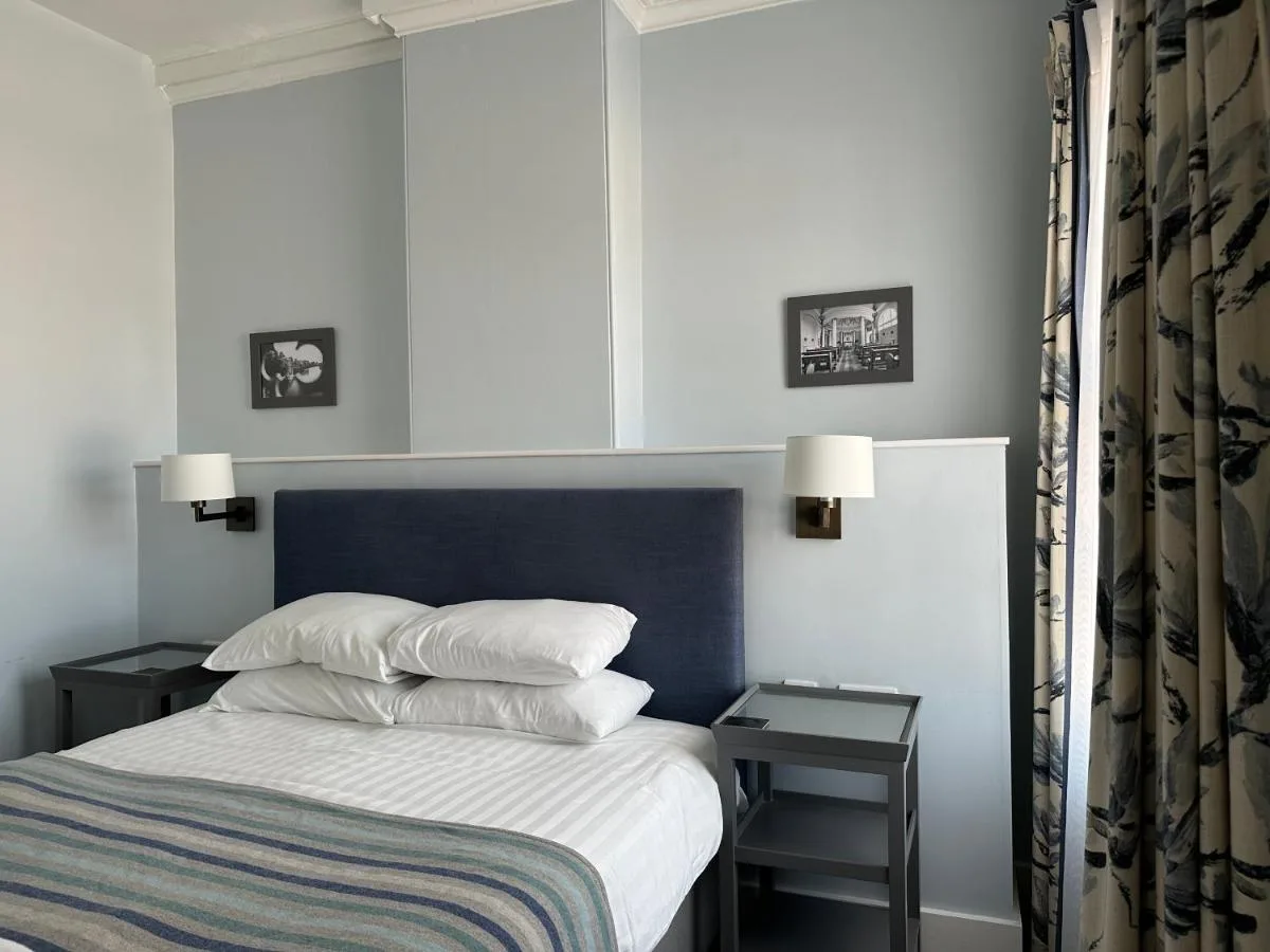 A bedroom with a blue headboard and pillows at the Bar Convent Guest House in York