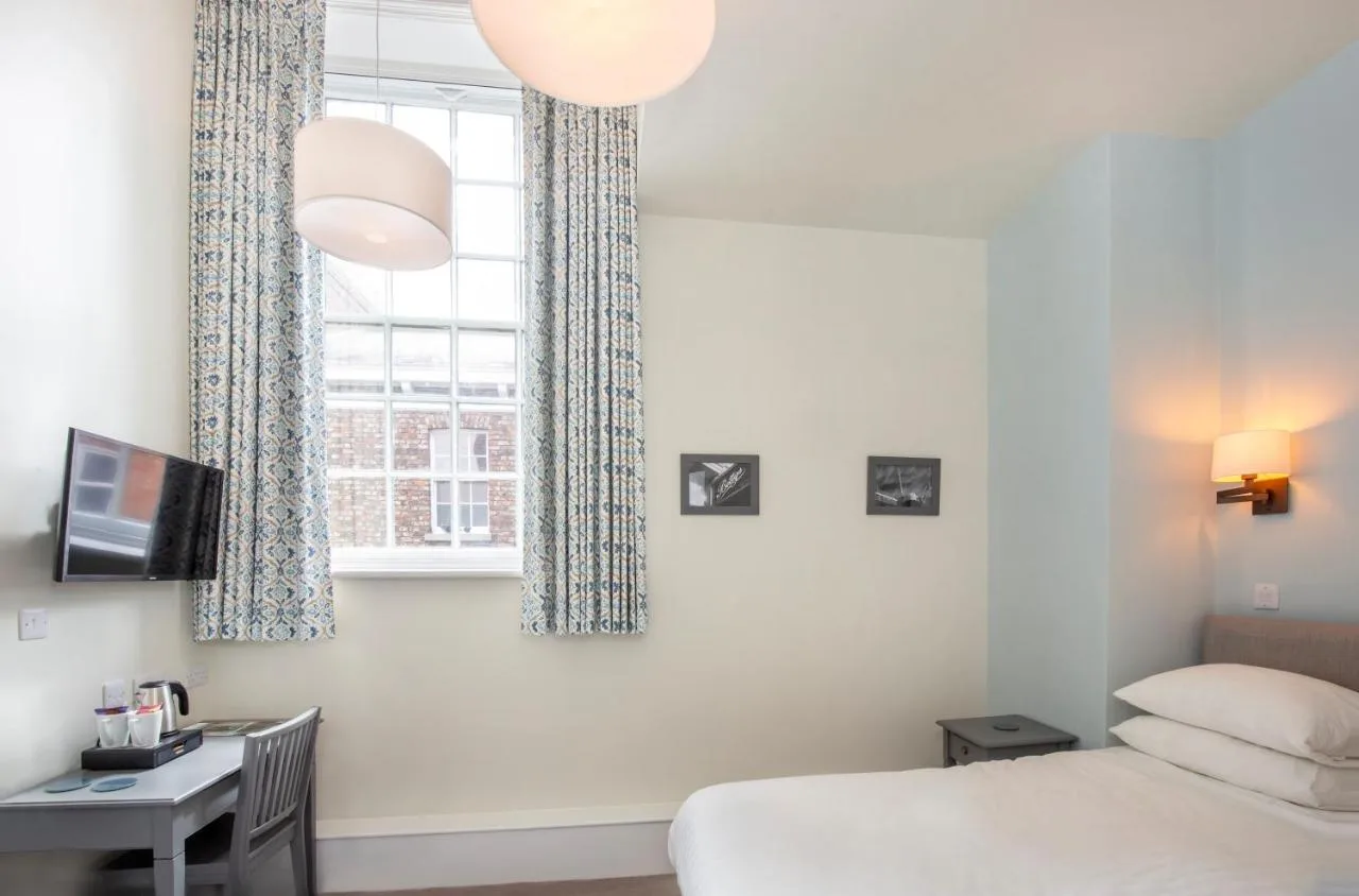 A bedroom with a desk and window at this York guest house near York Station